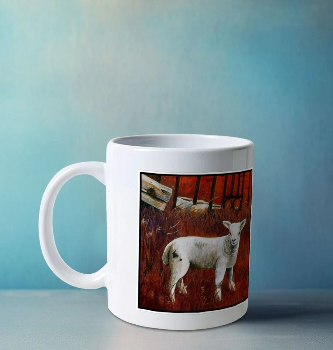 Image of a White Mug on a white worksurface featuring a modified copy of a detail from the painting 'The Gate' by Nick Dale. The handle is orientated to the left. The mug depicts a lamb in front of an ornamental garden gate reused by a farmer somewhere in North Devon, probably to the south of Valley of Rocks, Lynton. The lamb was observed on Lundy Island, Devon.