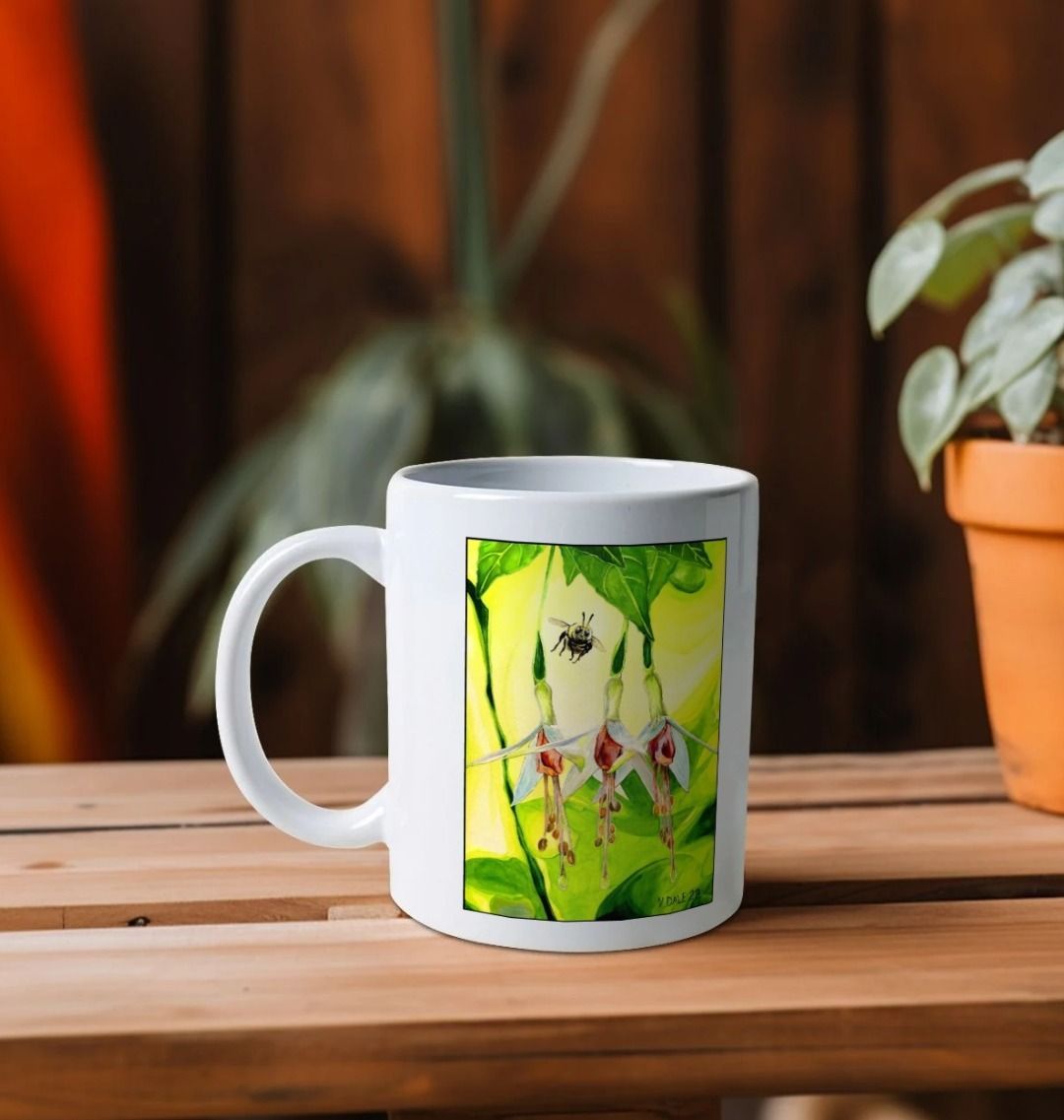 Image of a White Mug on a wooden shelf featuring a copy of the painting 'The Three Muses' by Nick Dale. The handle is orientated to the left. The mug depicts a close-up view of a bee approaching its prize. But which will it choose?