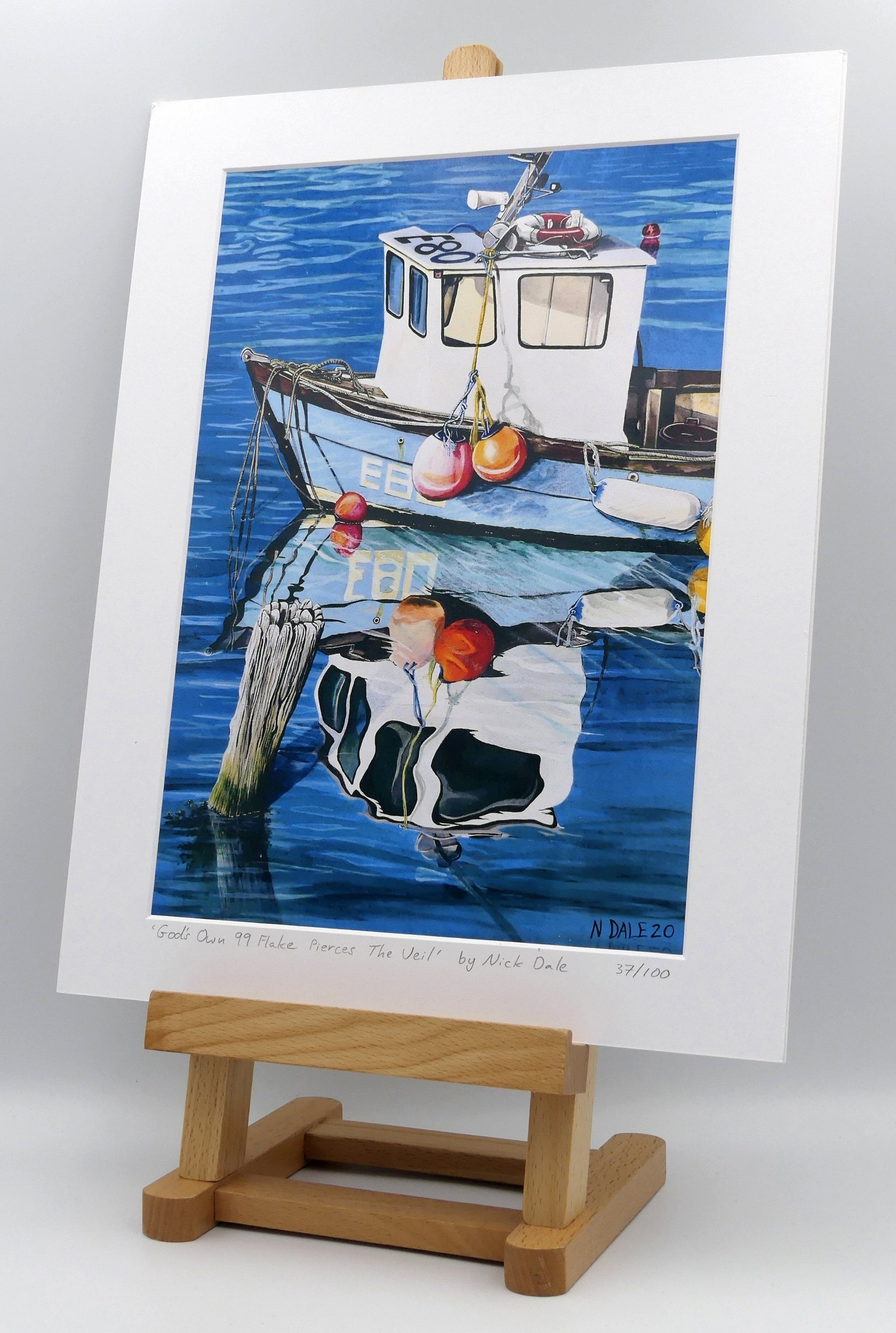 Image of a Medium Art Print featuring a copy of the painting 'God's Own 99 Flake Pierces The Veil' by Nick Dale. The print depicts a fishing boat at rest within the harbour of Lyme Regis, Dorset. The title is based on the similarity of the wooden pile to a chocolate flake as inserted into an ice cream cone. This seemed appropriate given the draw of the town to tourists. The print is situated on a small easel.