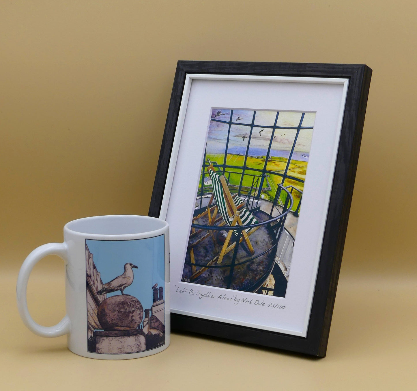 Image of a Small Art Print featuring a copy of the painting 'Let's Be Together Alone' by Nick Dale. The print depicts the view from the lantern room of the Old Light lighthouse on Beacon Hill, on the island of Lundy, Devon. The print is situated in a black frame next to a mug.