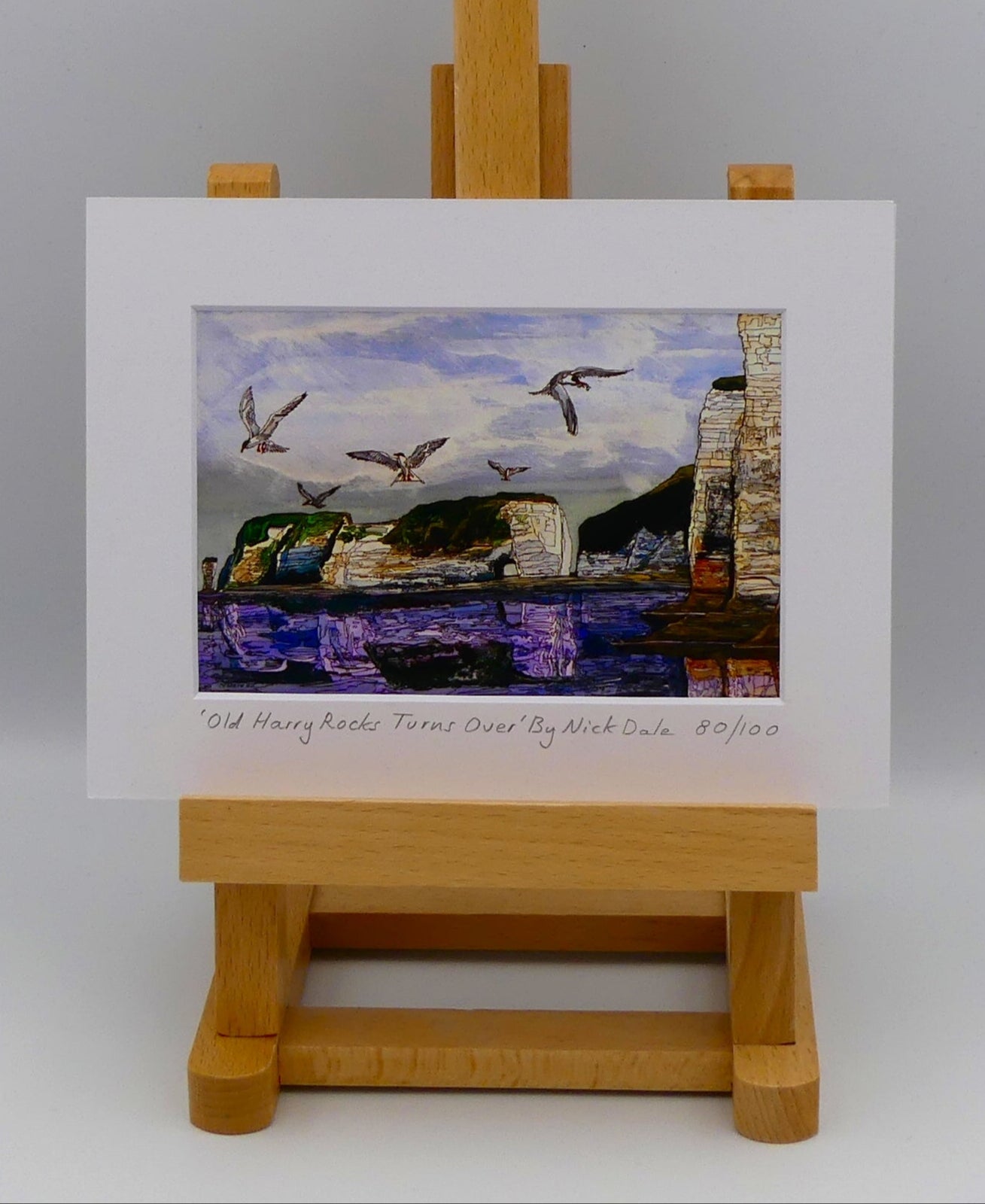 Image of a Small Art Print featuring a copy of the painting 'Old Harry Rocks Turns Over' by Nick Dale. The print depicts the view on a walk in March 2025 when the tide was completely out so I could walk to Old Harry Rocks. I never realised that that was ever possible. I had to add in the water when I painted it afterwards as it was completely missing. Turns also added to taste.  The print is situated on a small easel.