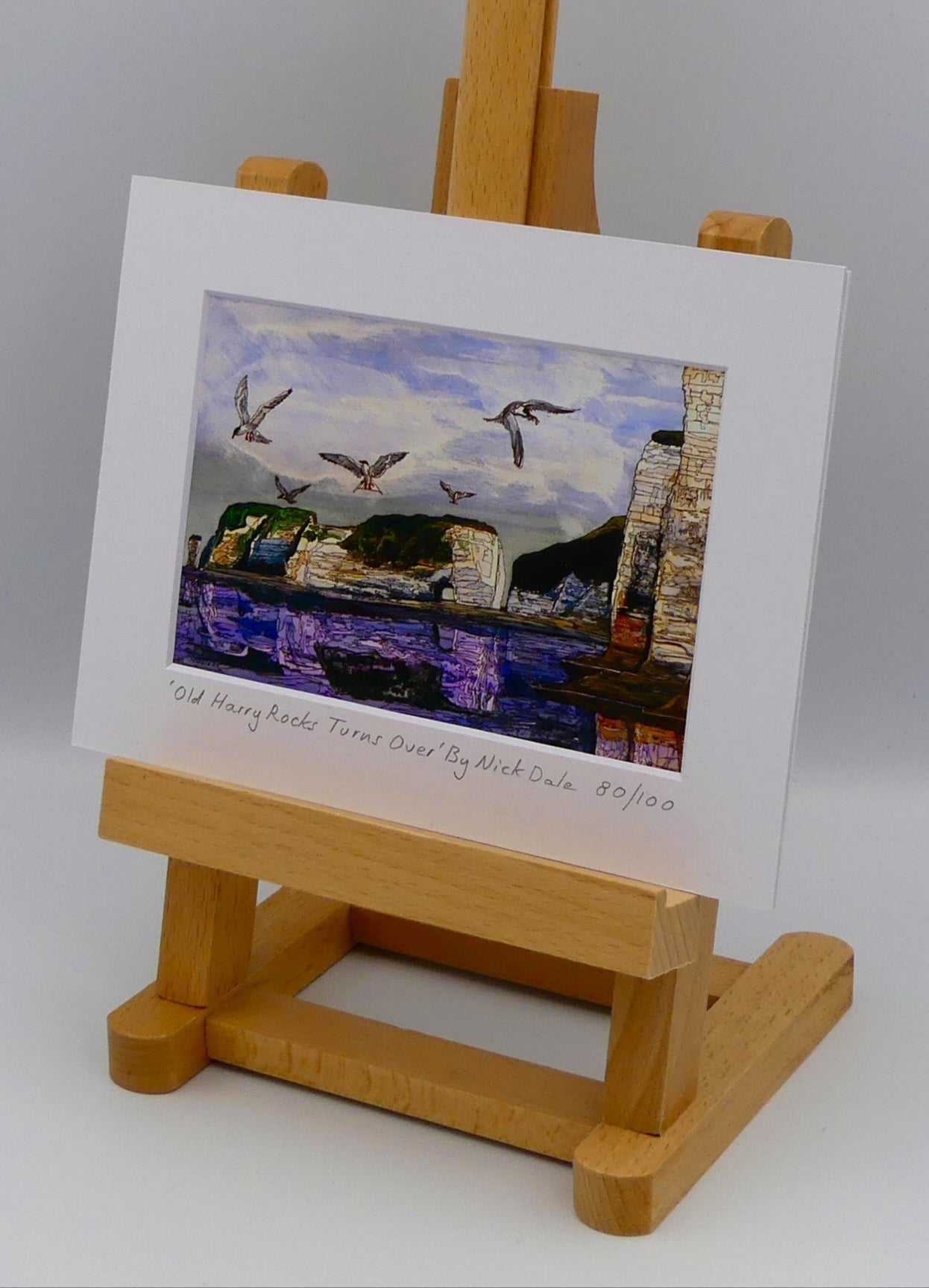 Image of a Small Art Print featuring a copy of the painting 'Old Harry Rocks Turns Over' by Nick Dale. The print depicts the view on a walk in March 2025 when the tide was completely out so I could walk to Old Harry Rocks. I never realised that that was ever possible. I had to add in the water when I painted it afterwards as it was completely missing. Turns also added to taste. The print is situated on a small easel.