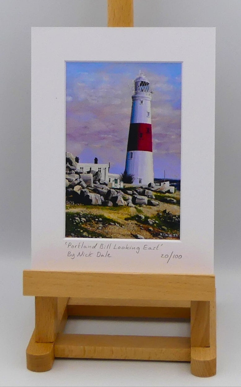 Image of a Small Art Print featuring a copy of the painting 'Portland Bill Looking East' by Nick Dale. The print depicts a view of Portland Bill Lighthouse as seen from the quarry area to the west, looking east. The print is situated on a small easel.