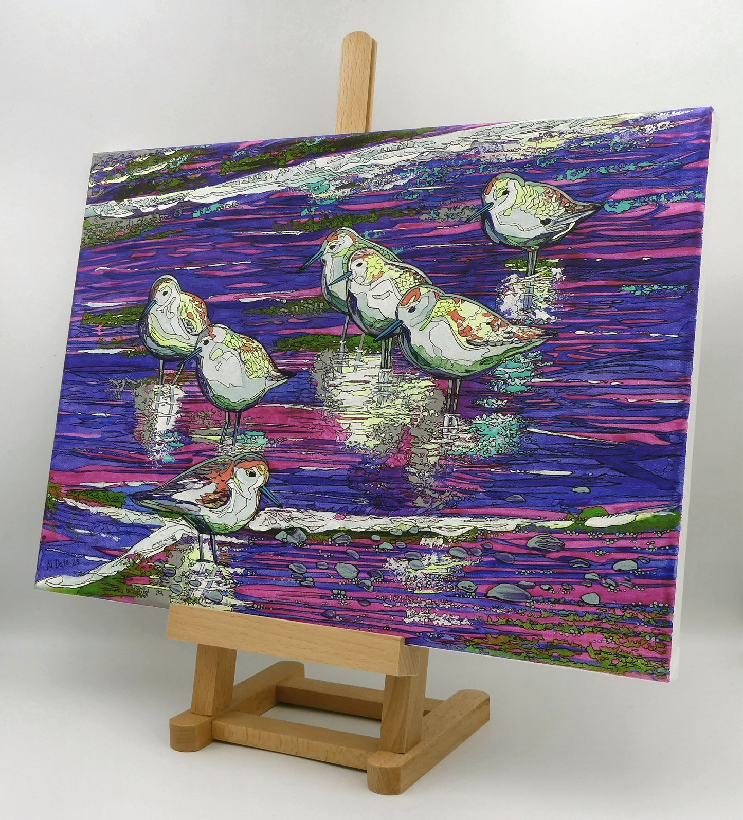 Image of the original painting 'Studland Sanderlings' by Nick Dale on an easel. The painting depicts a close up view of sanderlings on Studland Beach (Dorset).