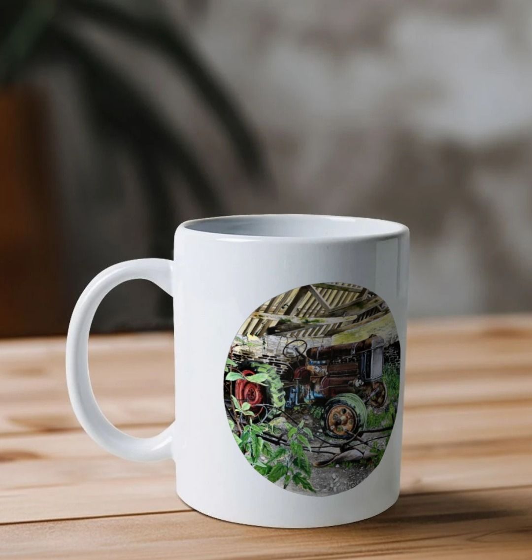Image of a White Mug on a table featuring a copy of the painting 'A Well Deserved Rest At Tyneham' by Nick Dale. The handle is orientated to the left. The mug depicts a Fordson Major tractor laid up in a farm building at the abandoned village of Tyneham in Dorset.