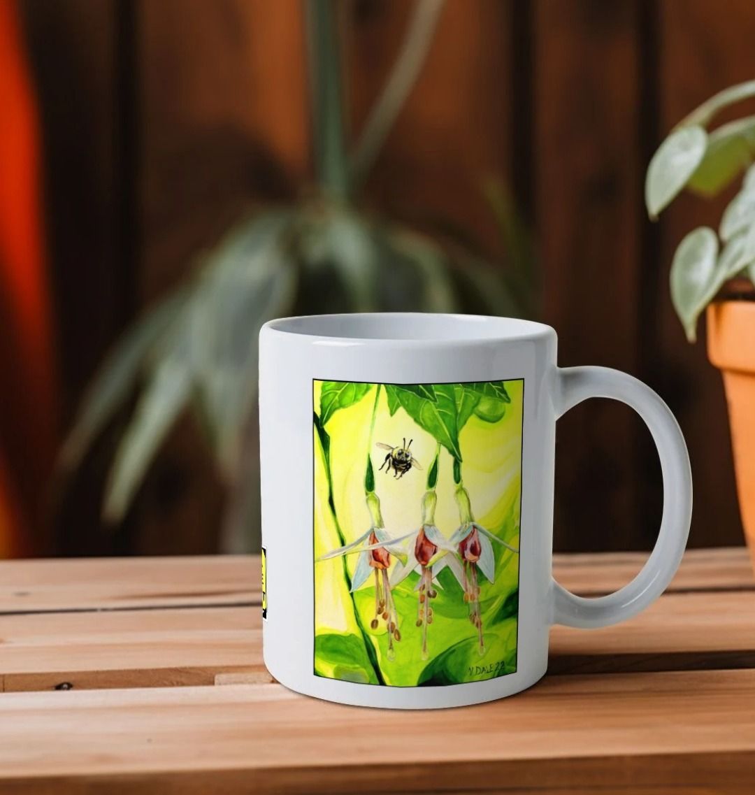 Image of a White Mug on a wooden shelf featuring a copy of the painting 'The Three Muses' by Nick Dale. The handle is orientated to the right. The mug depicts a close-up view of a bee approaching its prize. But which will it choose?