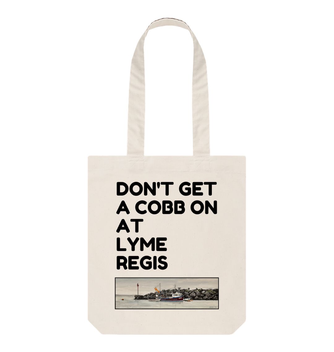 Image of a Natural Tote Bag featuring a copy of the painting 'End Of The Line' by Nick Dale with the slogan 'Don't Get A Cobb On At Lyme Regis' written above it. The bag depicts a fisherman preparing his catch for unloading at Lyme Regis as the birds line up on the breakwater and patiently await their turn to feed.