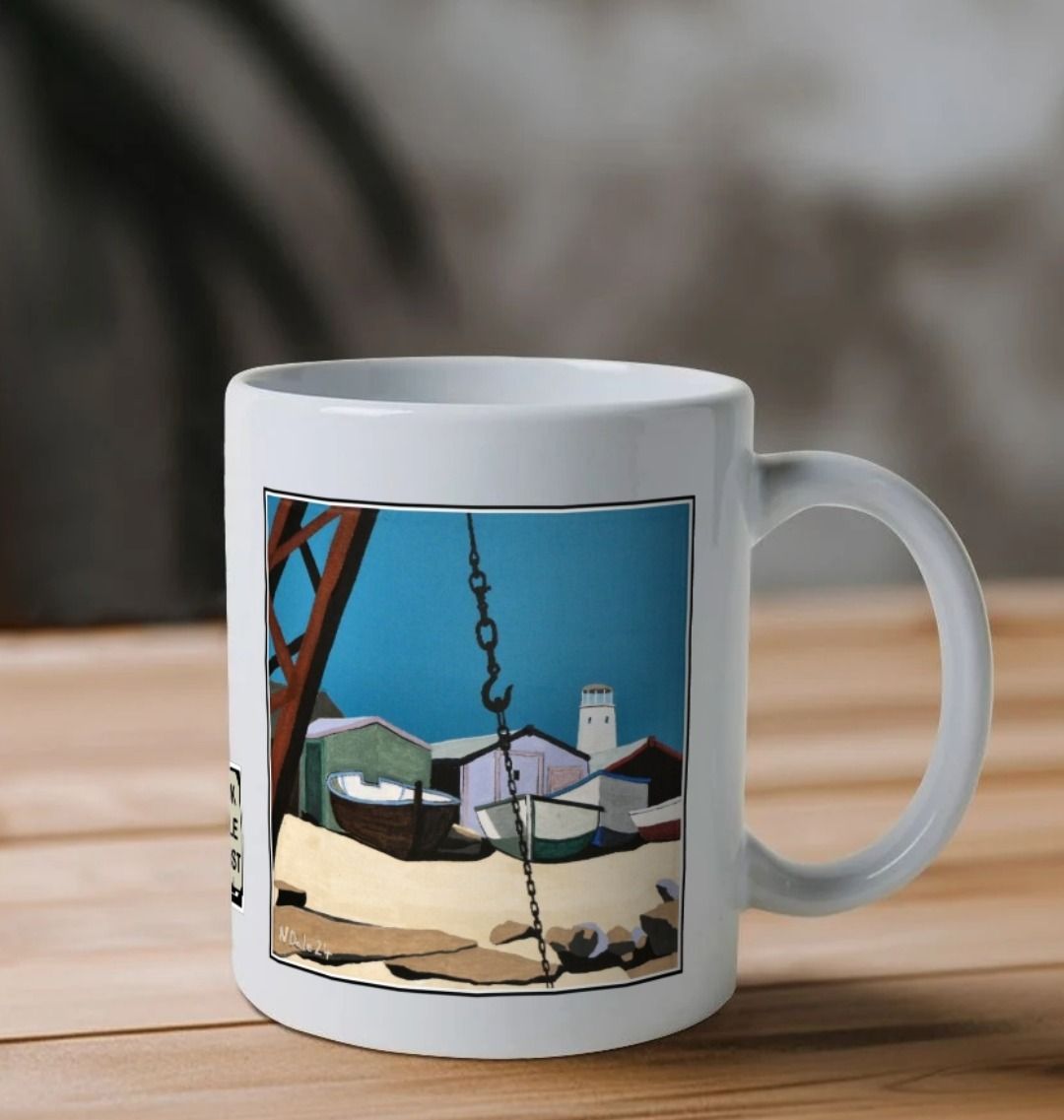 Image of a White Mug on a wooden shelf featuring a copy of the painting 'Old Lower Lighthouse, Portland' by Nick Dale. The handle is orientated to the right. The mug depicts the view from the Red Crane at Portland Bill, across to the Old Lower Lighthouse over the beach huts and small boats next to the stone loading quay.