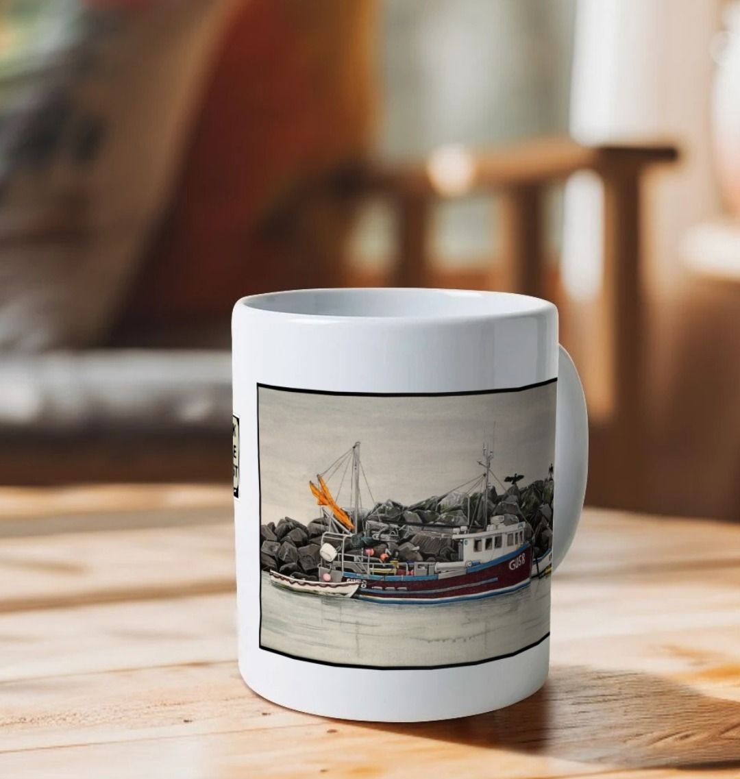 Image of a White Mug on a wooden table featuring 2 details from the painting 'End Of The Line' by Nick Dale. The detail showing the fishing boat is visible. The mug handle is obscured behind the mug. The mug depicts a scene where, as the fisherman prepares his catch for unloading at Lyme Regis, the birds line up on the breakwater and patiently await their turn to feed.