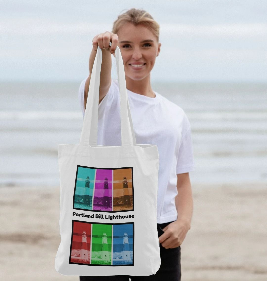Image of a female model holding a White Tote Bag featuring 6 digitally modified versions of the painting 'Rothko's Work Experience At Portland Bill Lighthouse' by Nick Dale, with the words 'Portland Bill Lighthouse' written between the lighthouse images that have been divided into 2 groups of 3 versions each. The bag depicts what might happen if the abstract painter Mark Rothko worked at Portland Bill Lighthouse in Portland, Dorset.