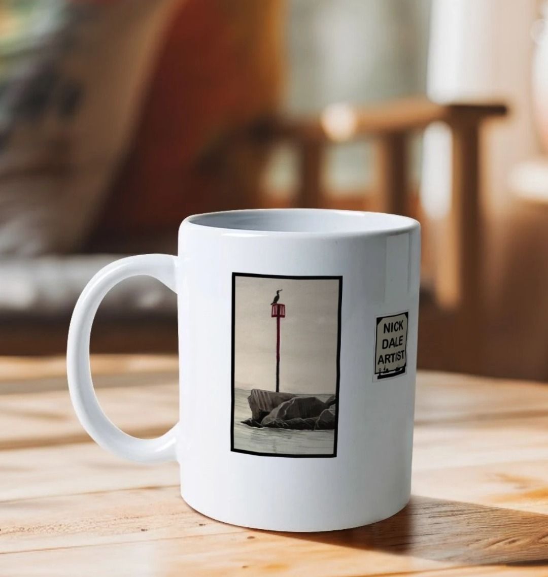 Image of a White Mug on a wooden table featuring 2 details from the painting 'End Of The Line' by Nick Dale. The detail showing the end of the breakwater is visible. Image also shows artist's logo on the mug. The handle is orientated to the left. The mug depicts a scene where, as the fisherman prepares his catch for unloading at Lyme Regis, the birds line up on the breakwater and patiently await their turn to feed.