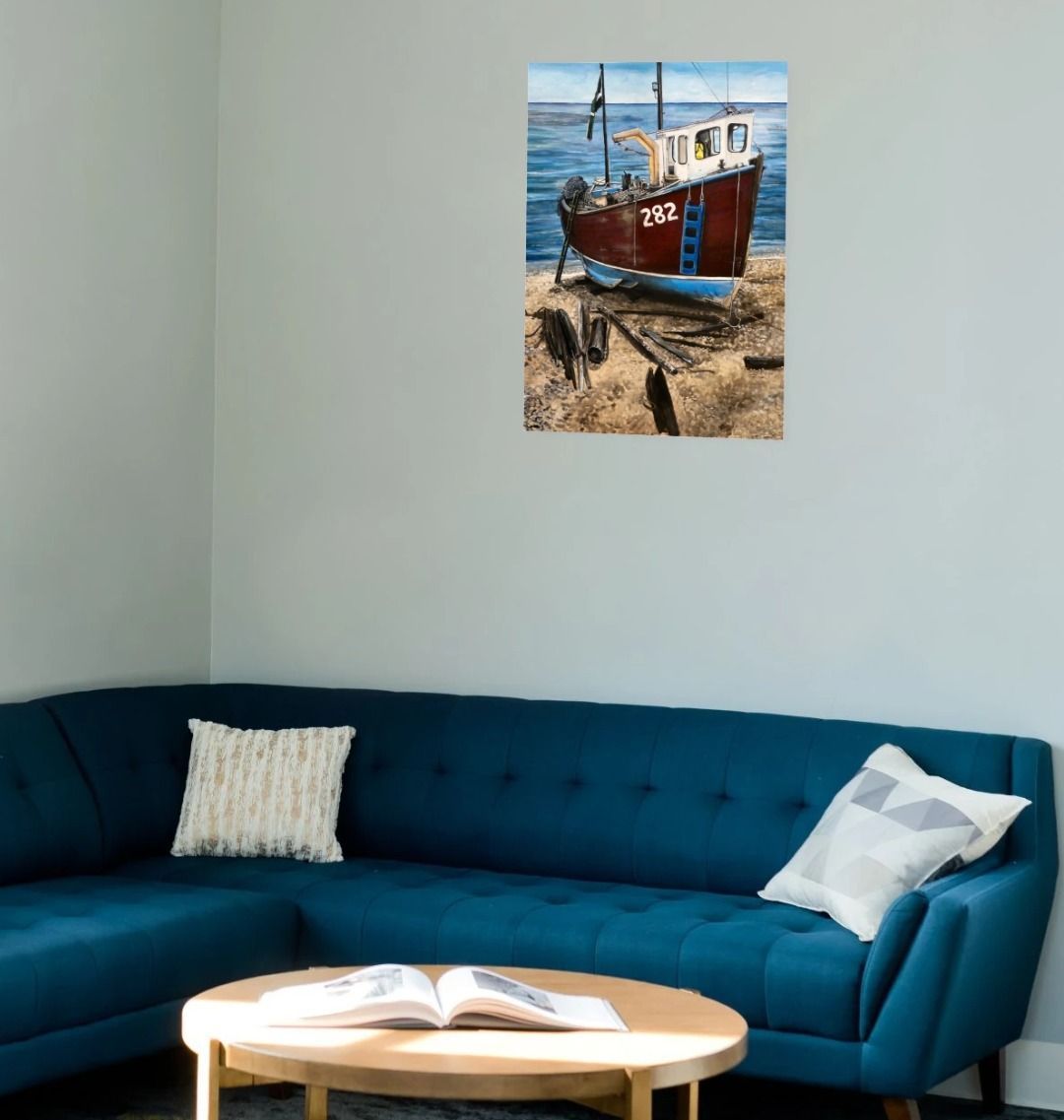 Image of a Large Art Print (A3 size) featuring a copy of the painting 'Relaxing Beer' by Nick Dale. As displayed on a wall above a sofa. The scene depicts a fishing boat beached at Beer, Devon. The wood is laid under the boats to aid in their winching up the shingle beach.