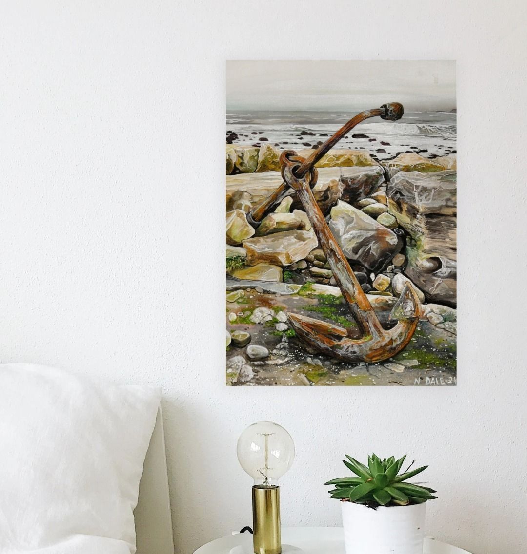 Image of a Large Art Print (A3 size) featuring a copy of the painting 'The Sea Anchors The Land To The Sky' by Nick Dale. As displayed on a wall next to a bed. The print depicts an old anchor lying at rest under a leaden sky upon the foreshore at Chapman's Pool, near Worth Matravers, Dorset.