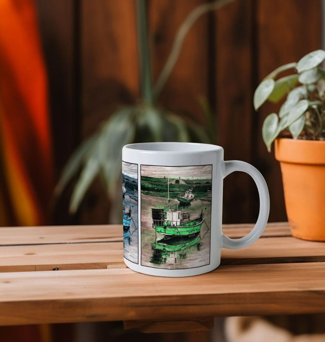 Image of a White Mug on a wooden shelf featuring multiple modified copies of the painting 'Lyme Regis at Low Tide' by Nick Dale. The handle is orientated to the right. The mug depicts 3 versions of a sunset scene where the fishing vessels rest on the floor of Lyme Regis harbour whilst the tourists enjoy the view from the Cobb. Each of the 3 versions is tinted a different colour; being red, blue and green.