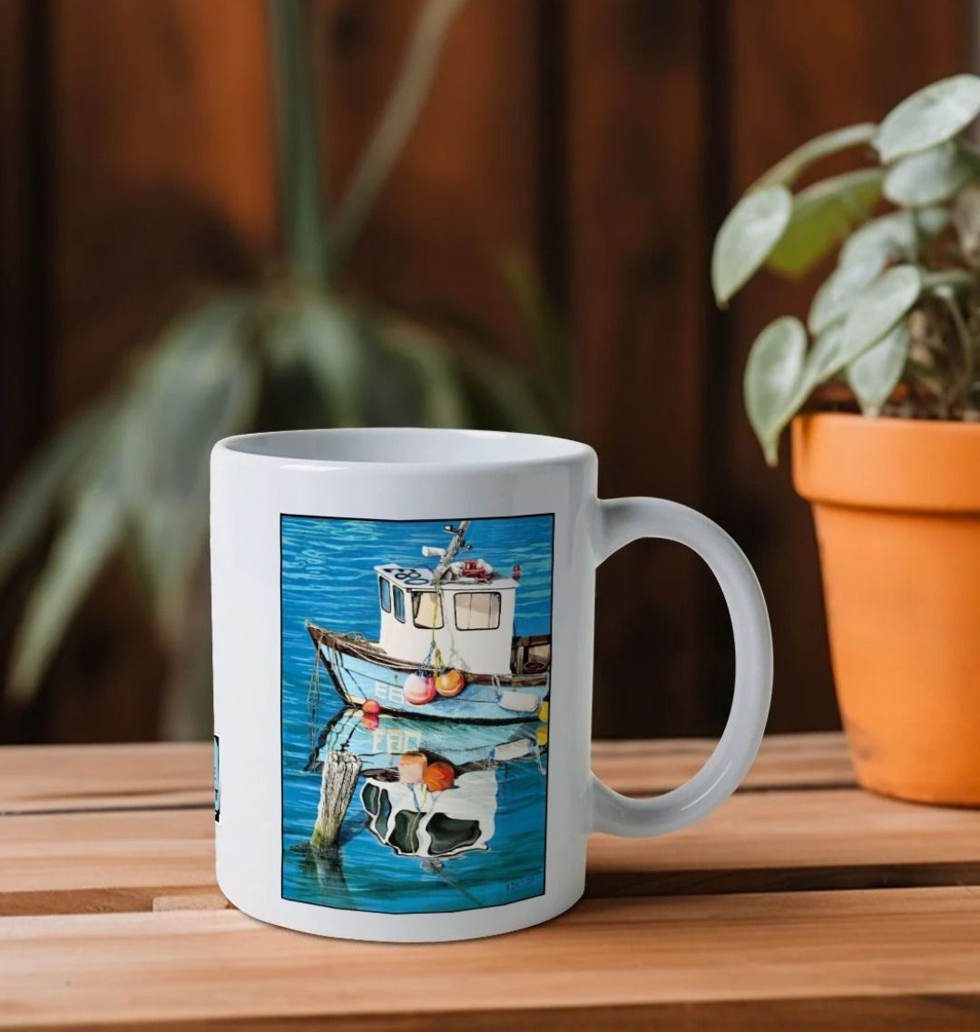 Image of a White Mug on a shelf featuring a copy of the painting 'God's Own 99 Flake Pierces The Veil' by Nick Dale. The handle is orientated to the right. The mug depicts a fishing boat at rest within the harbour of Lyme Regis, Dorset. The title is based on the similarity of the wooden pile to a chocolate flake as inserted into an ice cream cone. This seemed appropriate given the draw of the town to tourists.
