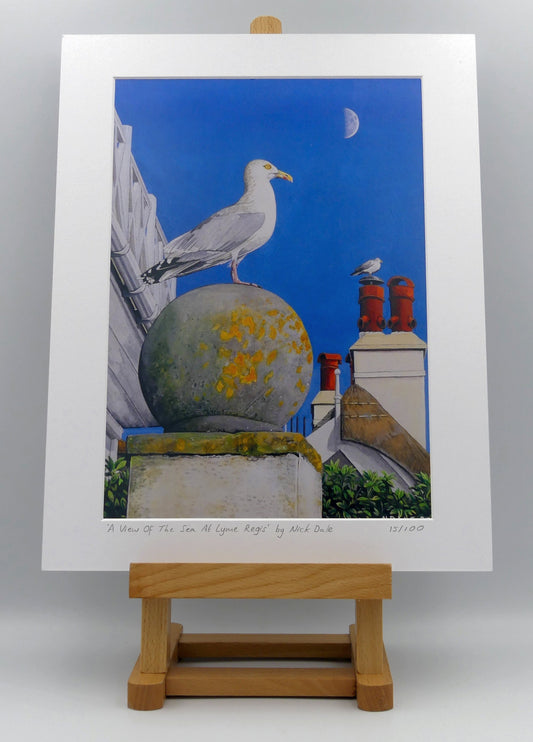 Image of Medium Art Print featuring a copy of the painting 'A View Of The Sea At Lyme Regis' by Nick Dale. The print depicts a gull and buildings along Marine Parade, Lyme Regis. The print is situated on a small easel.