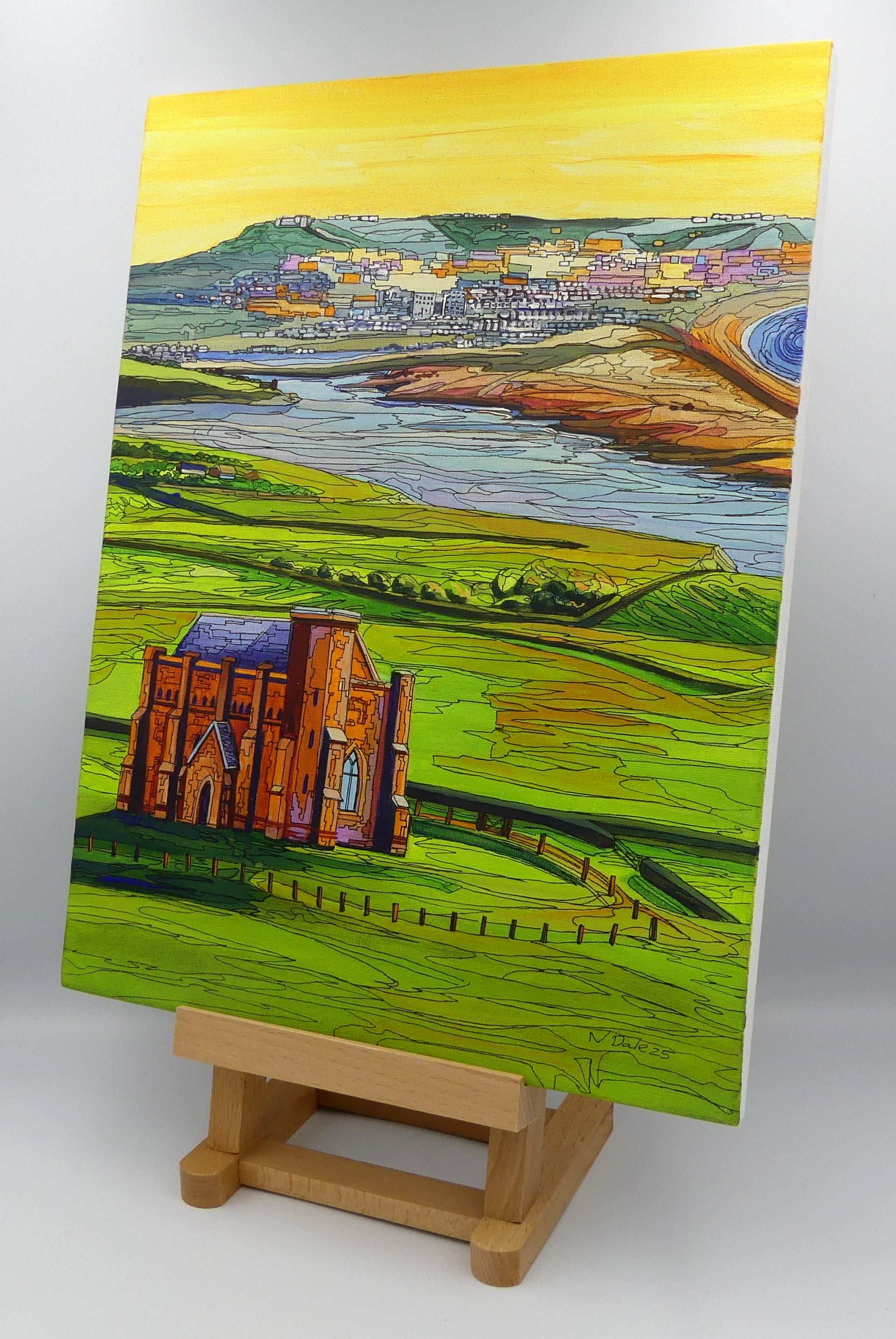 Image of the original painting 'Abbotsbury To Portland' by Nick Dale on a small easel. The painting depicts the view along the Dorset coast from St Catherine's Chapel above Abbotsbury, across The Fleet lagoon to Chesil Beach and ultimately to Portland beyond it.