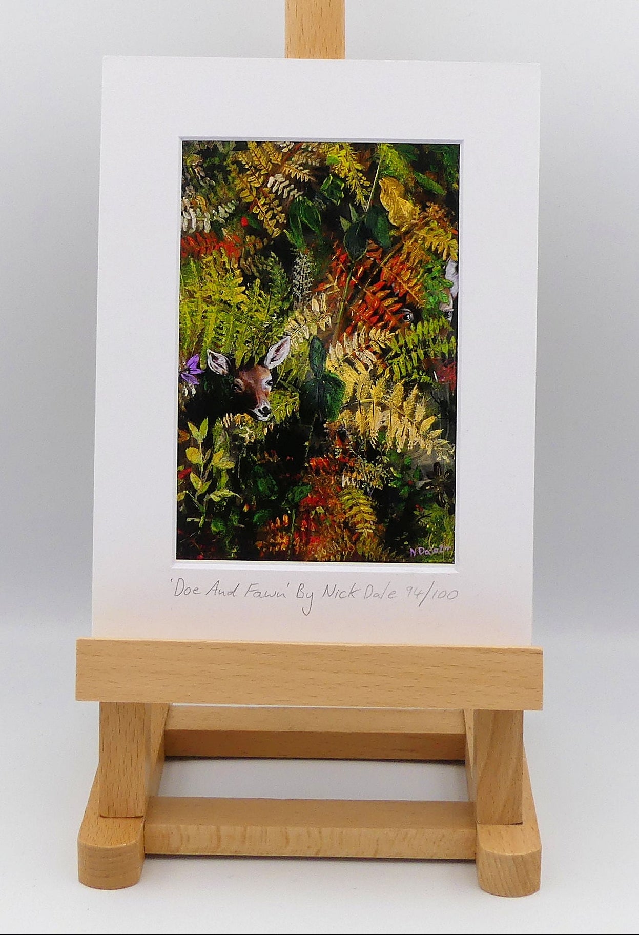 Image of a Small Art Print featuring a copy of the painting 'Doe And Fawn' by Nick Dale. The print depicts a Row Deer doe and fawn hiding in the dense undergrowth with only their heads visible.  The print is situated on a small easel.