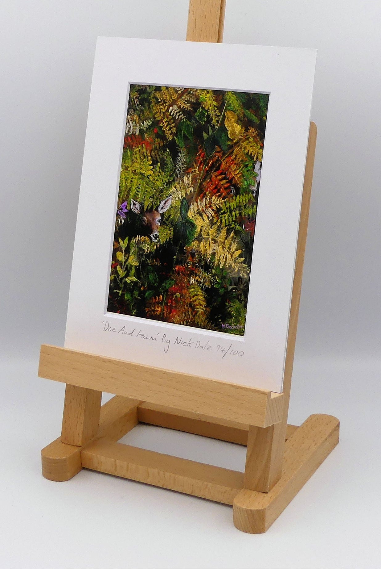 Image of a Small Art Print featuring a copy of the painting 'Doe And Fawn' by Nick Dale. The print depicts a Row Deer doe and fawn hiding in the dense undergrowth with only their heads visible. The print is situated on a small easel.