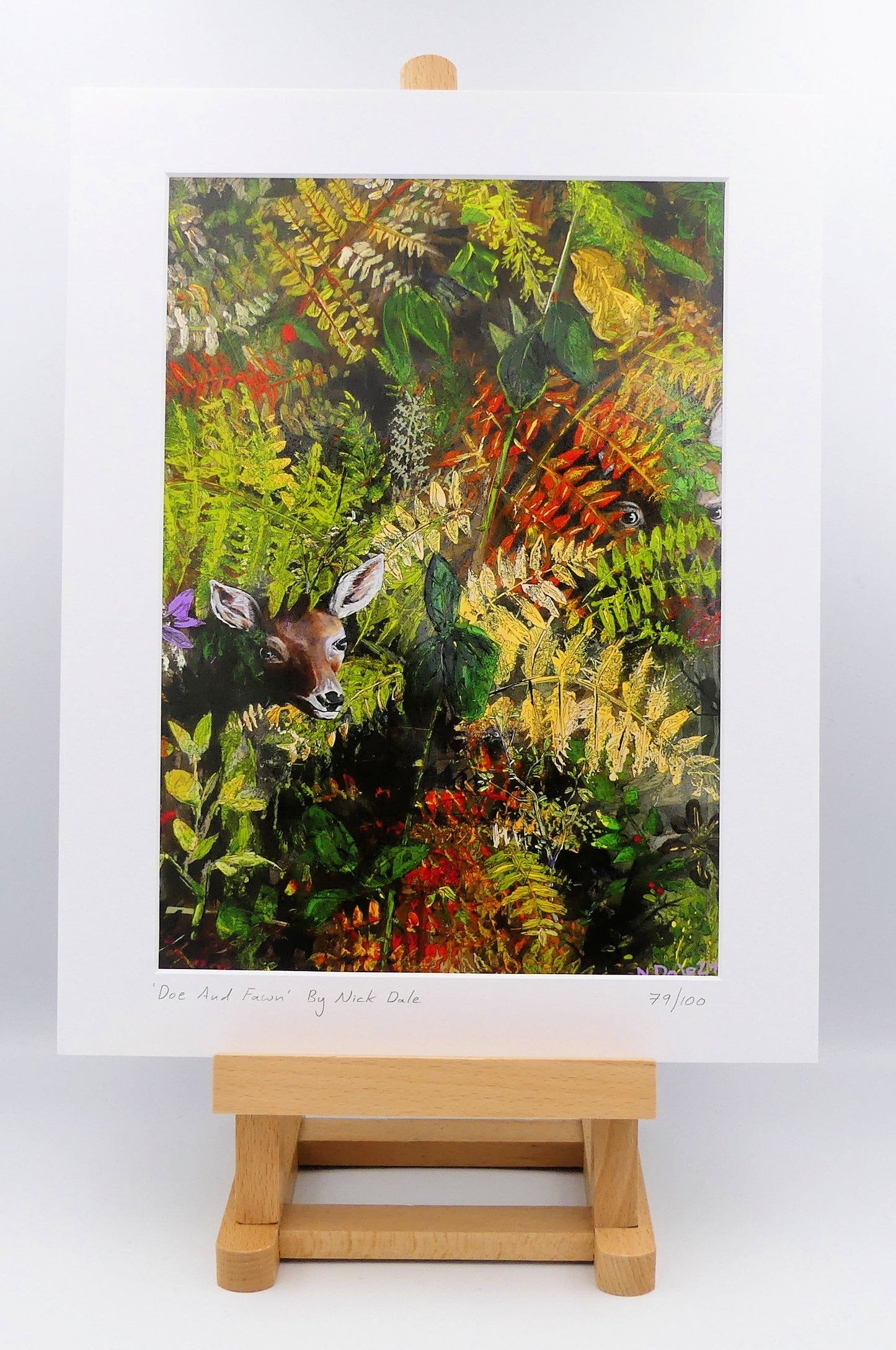 Image of a Medium Art Print featuring a copy of the painting 'Doe And Fawn' by Nick Dale. The print depicts a Row Deer doe and fawn hiding in the dense undergrowth with only their heads visible. The print is situated on a small easel.
