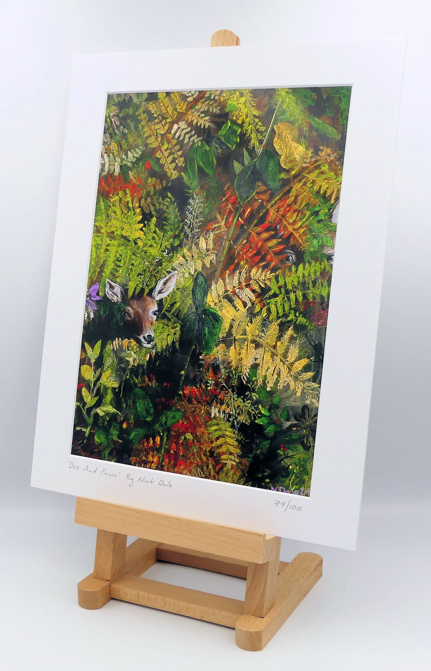Image of a Medium Art Print featuring a copy of the painting 'Doe And Fawn' by Nick Dale. The print depicts a Row Deer doe and fawn hiding in the dense undergrowth with only their heads visible. The print is situated on a small easel.