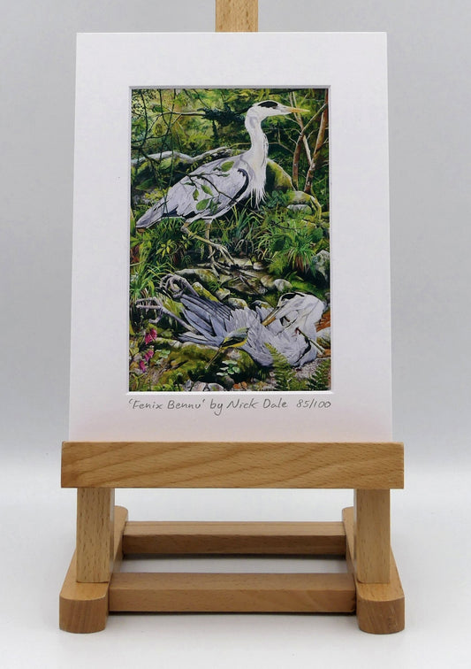 Image of a Small Art Print featuring a copy of the painting 'Fenix Bennu' by Nick Dale. The print depicts 2 grey herons (1 living & 1 dead) & is named after the Egyptian god Bennu; which may be the origins of the phoenix legend. 'Fenix' is Anglo-Saxon for phoenix & the scene has been transposed to a river in Devon. The blood of the dead heron is smoking where it drips on the ground; suggesting that this is indeed a phoenix. The print is situated on a small easel.