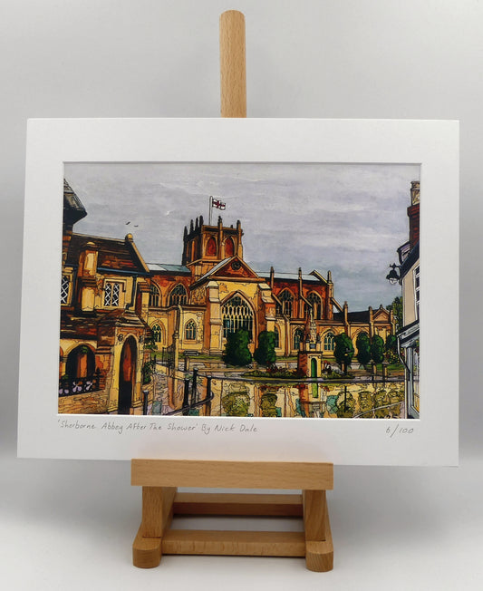 Image of a Medium Art Print featuring a copy of the painting 'Sherborne Abbey After The Shower' by Nick Dale. The print depicts a view of Sherborne Abbey (also known as the Abbey Church of St. Mary the Virgin), in Sherborne, Dorset. On the left hand side can be seen St Johns' Almshouse.
The print is situated on a small easel.