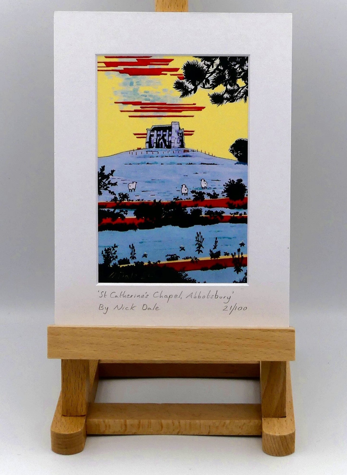 Image of Small Art Print featuring a copy of the painting 'St Catherine's Chapel, Abbotsbury' by Nick Dale. The print depicts the Medieval St Catherine's Chapel which is positioned overlooking the village of Abbotsbury. The print is situated on a small easel.