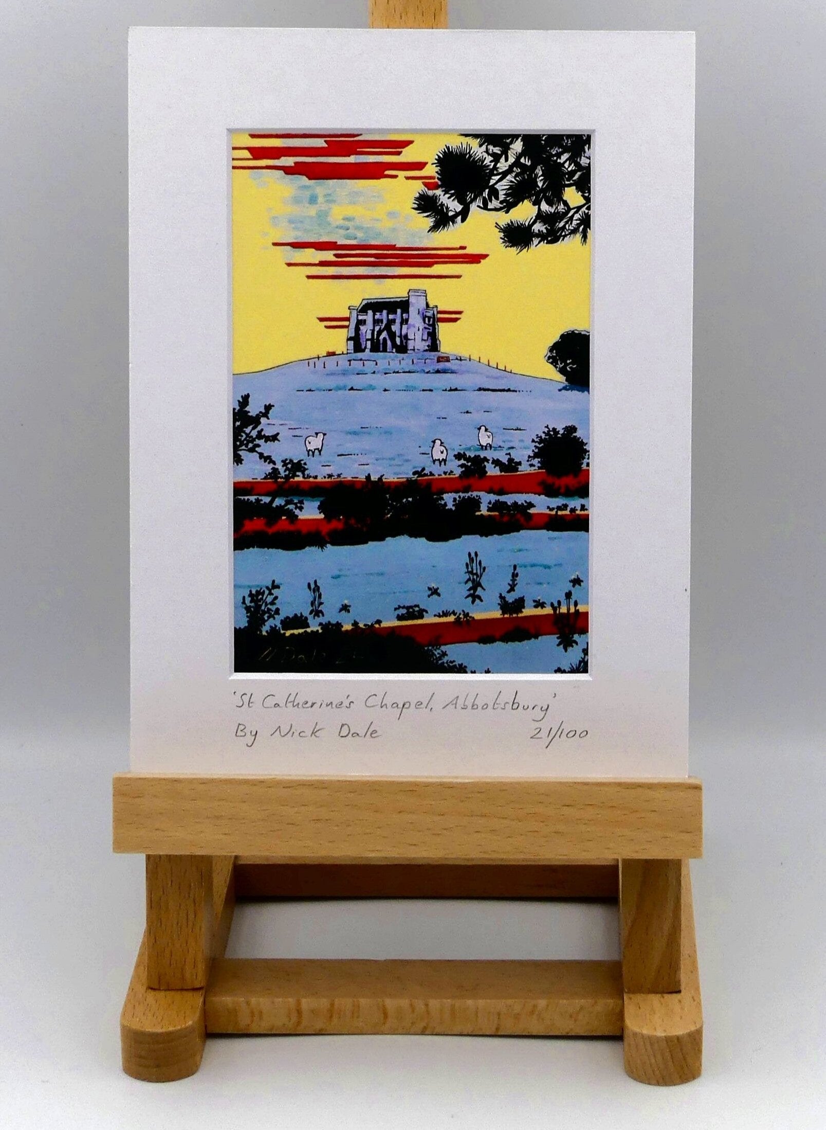 Image of Small Art Print featuring a copy of the painting 'St Catherine's Chapel, Abbotsbury' by Nick Dale. The print depicts the Medieval St Catherine's Chapel which is positioned overlooking the village of Abbotsbury. The print is situated on a small easel.