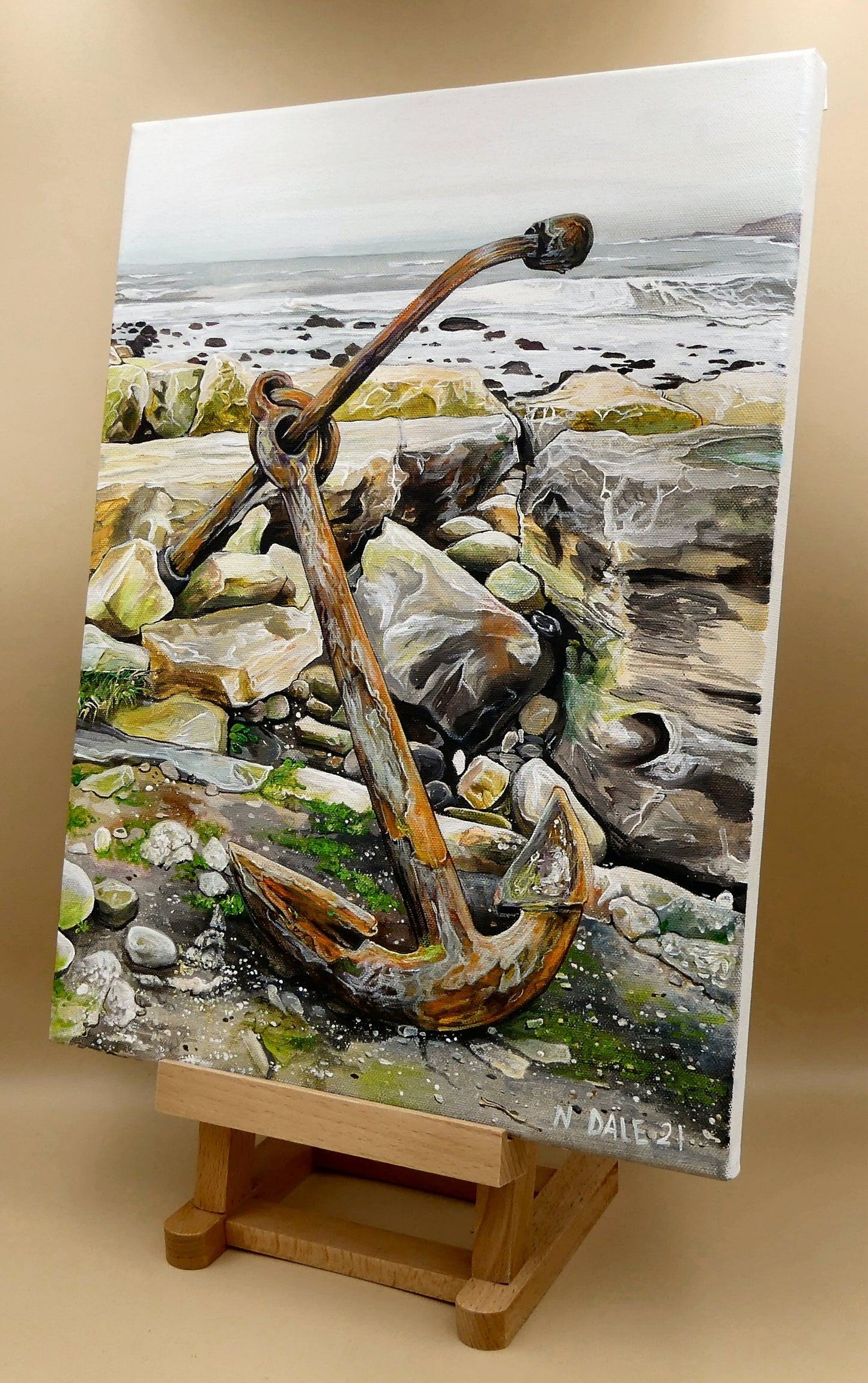 Image of the original painting 'The Sea Anchors The Land To The Sky' by Nick Dale on a small easel. The painting depicts an old anchor lying at rest under a leaden sky upon the foreshore at Chapman's Pool, near Worth Matravers, Dorset.