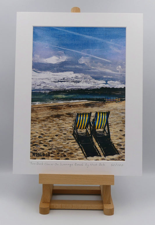 Image of a Medium Art Print featuring a copy of the painting 'Two Deck Chairs On Swanage Beach' by Nick Dale. The print depicts  two deck chairs overlooking the calm water from Swanage Beach (Dorset) towards Peveril Point. The print is situated on a small easel.