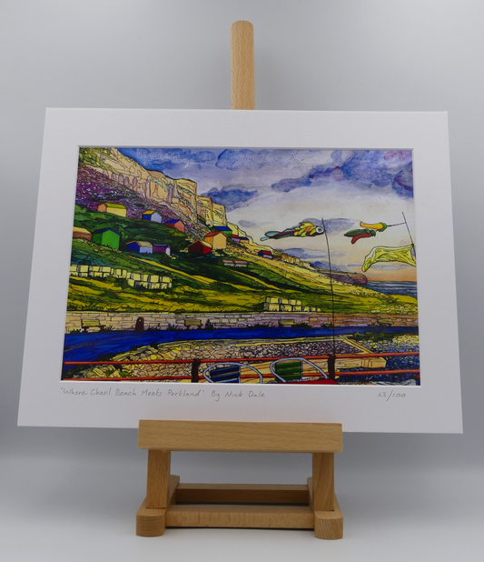 Image of a Medium Art Print featuring a copy of the painting 'Where Chesil Beach Meets Portland' by Nick Dale. The print depicts the point where Chesil Beach meets the Isle of Portland, Dorset. In the foreground are the chairs and decorative flags of Quiddles Café Beach Bar. On the slopes below the cliffs of Portland are the many beach huts which overlook the iconic Chesil Cove. The print is situated on a small easel.