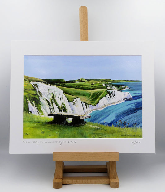 Image of a Medium Art Print featuring a copy of the painting 'White Nothe, SW Coast Path' by Nick Dale. The print depicts a view along the Jurassic Coast from the White Nothe chalk headland east of Ringstead Bay. The view looks east over Bat's Head, Swyre Head and Durdle Door to St Oswald's Bay & beyond. The print is situated on a small easel.