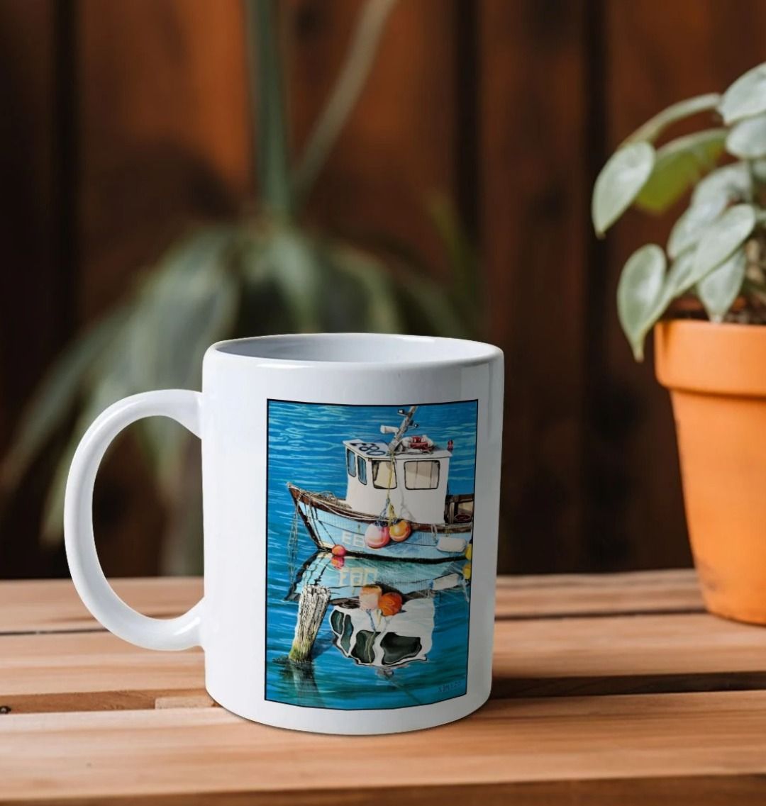 Image of a White Mug on a shelf featuring a copy of the painting 'God's Own 99 Flake Pierces The Veil' by Nick Dale. The handle is orientated to the left. The mug depicts a fishing boat at rest within the harbour of Lyme Regis, Dorset. The title is based on the similarity of the wooden pile to a chocolate flake as inserted into an ice cream cone. This seemed appropriate given the draw of the town to tourists.