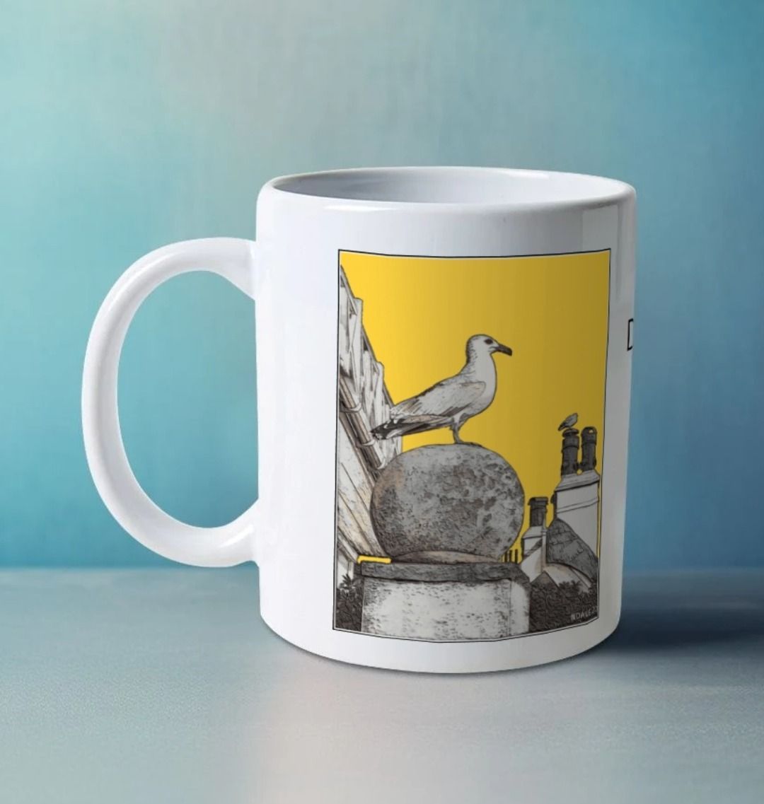 Image of a White Mug on a white table featuring a modified copy of the painting 'A View Of The Sea At Lyme Regis' by Nick Dale - this being the 'Yellow' version. The handle is orientated to the left. The mug depicts a gull and buildings along Marine Parade, Lyme Regis.