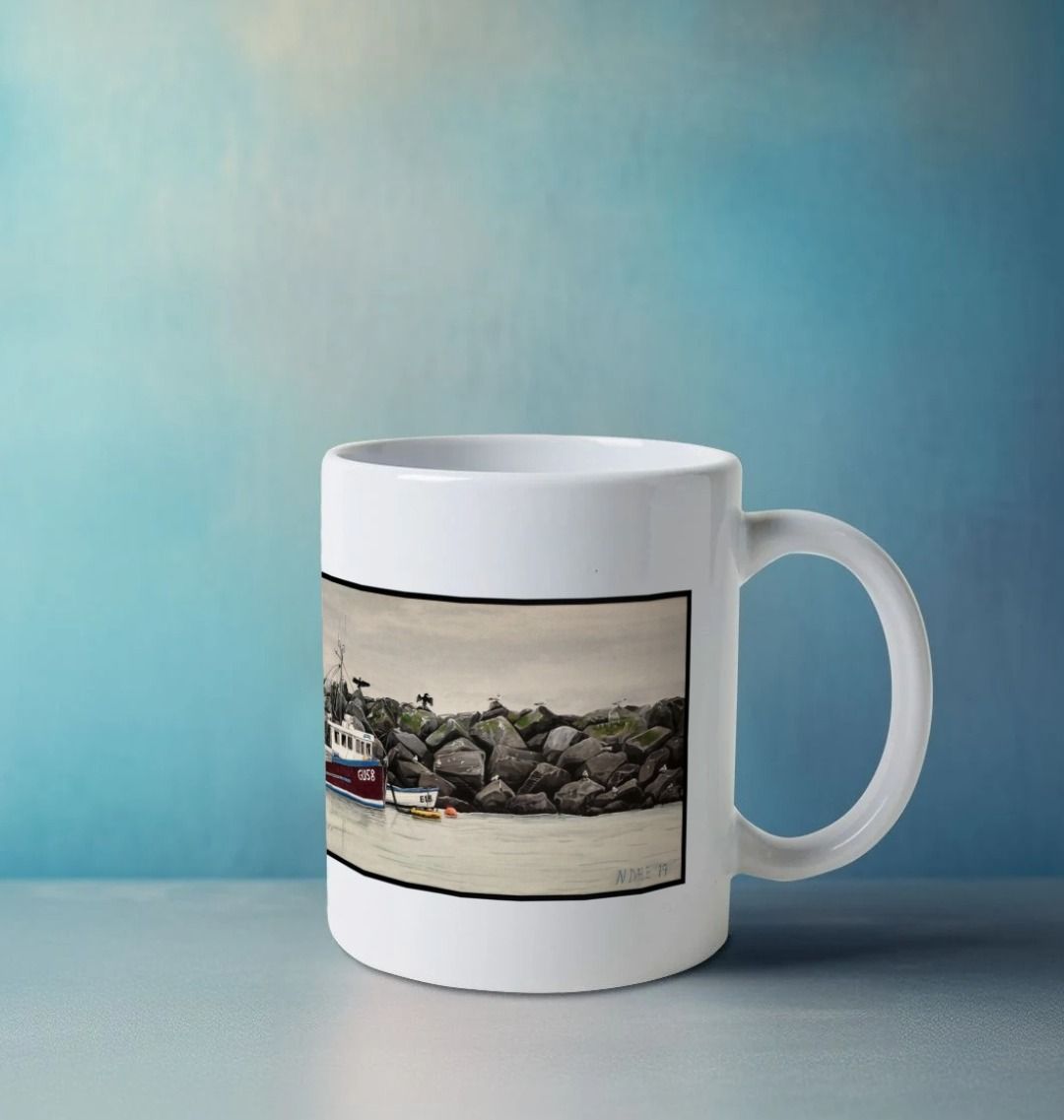 Image of a White Mug on a white table featuring a copy of the painting 'End Of The Line' by Nick Dale. The handle is orientated to the right. The mug depicts a scene where, as the fisherman prepares his catch for unloading at Lyme Regis, the birds line up on the breakwater and patiently await their turn to feed.
