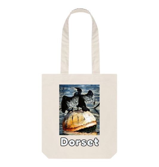 Image of a Natural Tote Bag featuring a copy of the painting 'Cormorant At West Bay' by Nick Dale. The bag depicts a close-up of a cormorant sunbathing on a mooring buoy in West Bay's harbour in Dorset.
