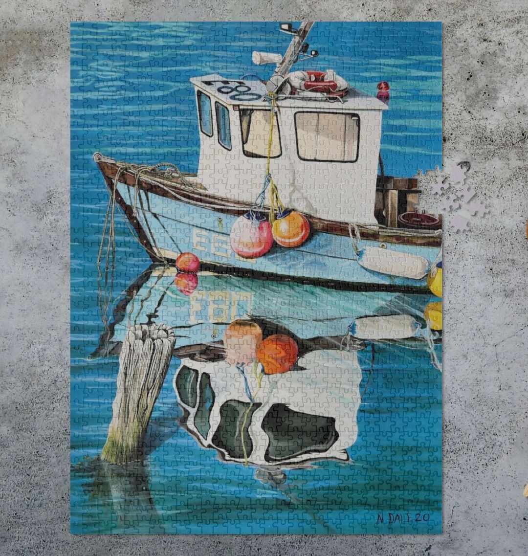 Image of a 1000 Piece Jigsaw Puzzle featuring a copy of the painting 'God's Own 99 Flake Pierces The Veil' by Nick Dale. As displayed partially completed on a grey surface. The jigsaw depicts a fishing boat at rest within the harbour of Lyme Regis, Dorset. The title is based on the similarity of the wooden pile to a chocolate flake as inserted into an ice cream cone. This seemed appropriate given the draw of the town to tourists.