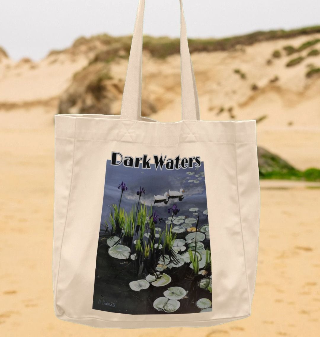 Image of a suspended Natural Shopper Tote Bag featuring a copy of the painting 'Dark Waters' by Nick Dale, with the words 'Dark Waters' written above it. The bag depicts lily pads, irises and ducks on a pond at Knightshayes Court, Devon.
