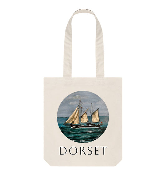 Image of a Natural Tote Bag featuring a copy of the painting 'Moonfleet Sailing Past Portland' by Nick Dale, with the word 'Dorset' written beneath it. The bag depicts the tall ship Moonfleet sailing past the western coast of Portland, Dorset. As observed from Ringstead Beach.