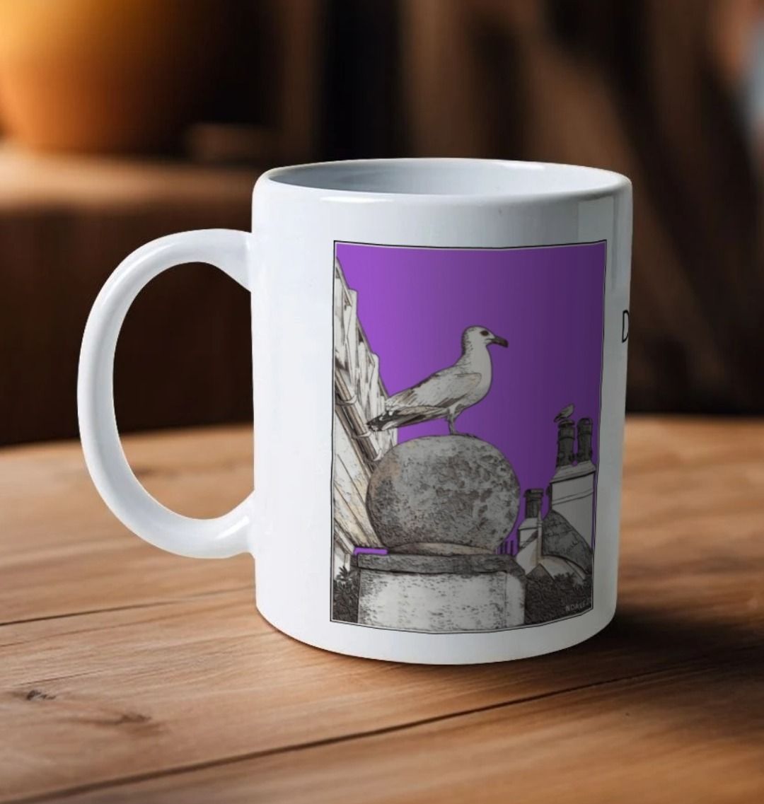 Image of a White Mug on a wooden table featuring a modified copy of the painting 'A View Of The Sea At Lyme Regis' by Nick Dale - this being the 'Purple' version. The handle is orientated to the left. The mug depicts a gull and buildings along Marine Parade, Lyme Regis.