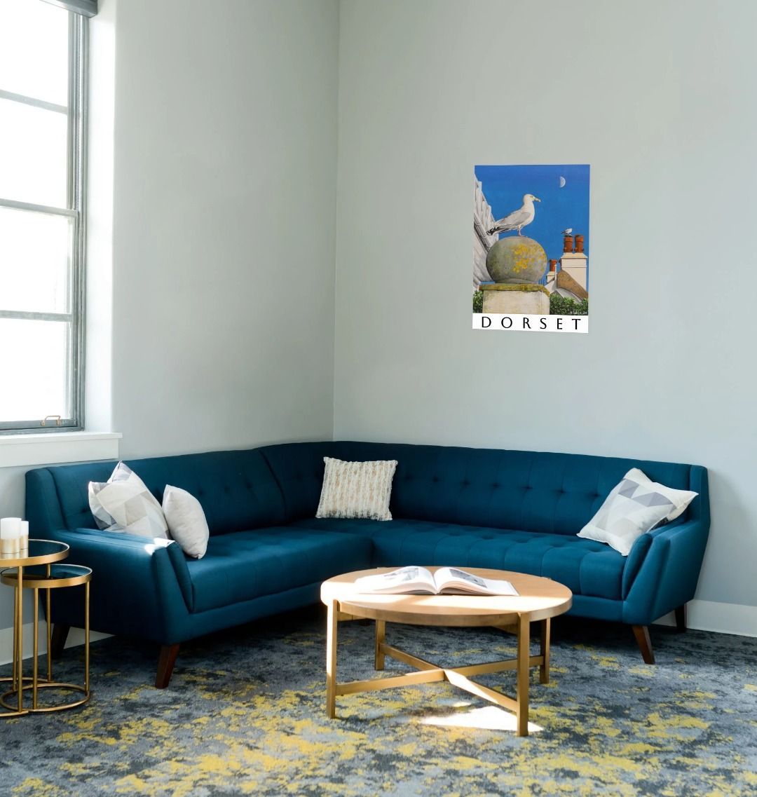 Image of a Large Art Print (A3 size) featuring a copy of the painting 'A View Of The Sea At Lyme Regis' by Nick Dale; as displayed on a wall above a sofa. The print depicts a gull and buildings along Marine Parade, Lyme Regis.