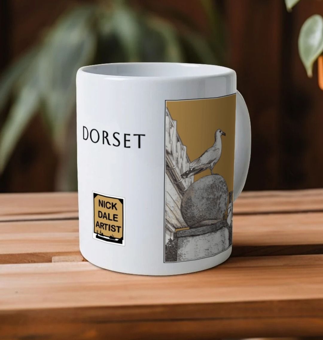 Image of a White Mug on a wooden shelf featuring a modified copy of the painting 'A View Of The Sea At Lyme Regis' by Nick Dale - this being the 'Light Brown' version. Image also shows the artist's logo on the mug with the word 'Dorset' written above it. The mug handle is obscured behind the mug. The mug depicts a gull and buildings along Marine Parade, Lyme Regis.