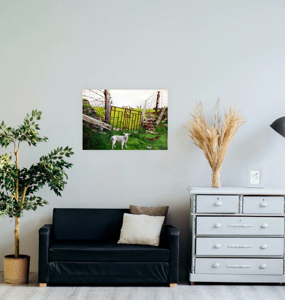 Image of a Large Art Print (A3 size) featuring a copy of the painting 'The Gate' by Nick Dale. As displayed on a wall above a small sofa. The print depicts a lamb in front of an ornamental garden gate reused by a farmer somewhere in North Devon, probably to the south of Valley of Rocks, Lynton. The lamb was observed on Lundy Island, Devon.
